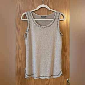 Very light tank top. Slight see through. Metal round detail around neck and arms